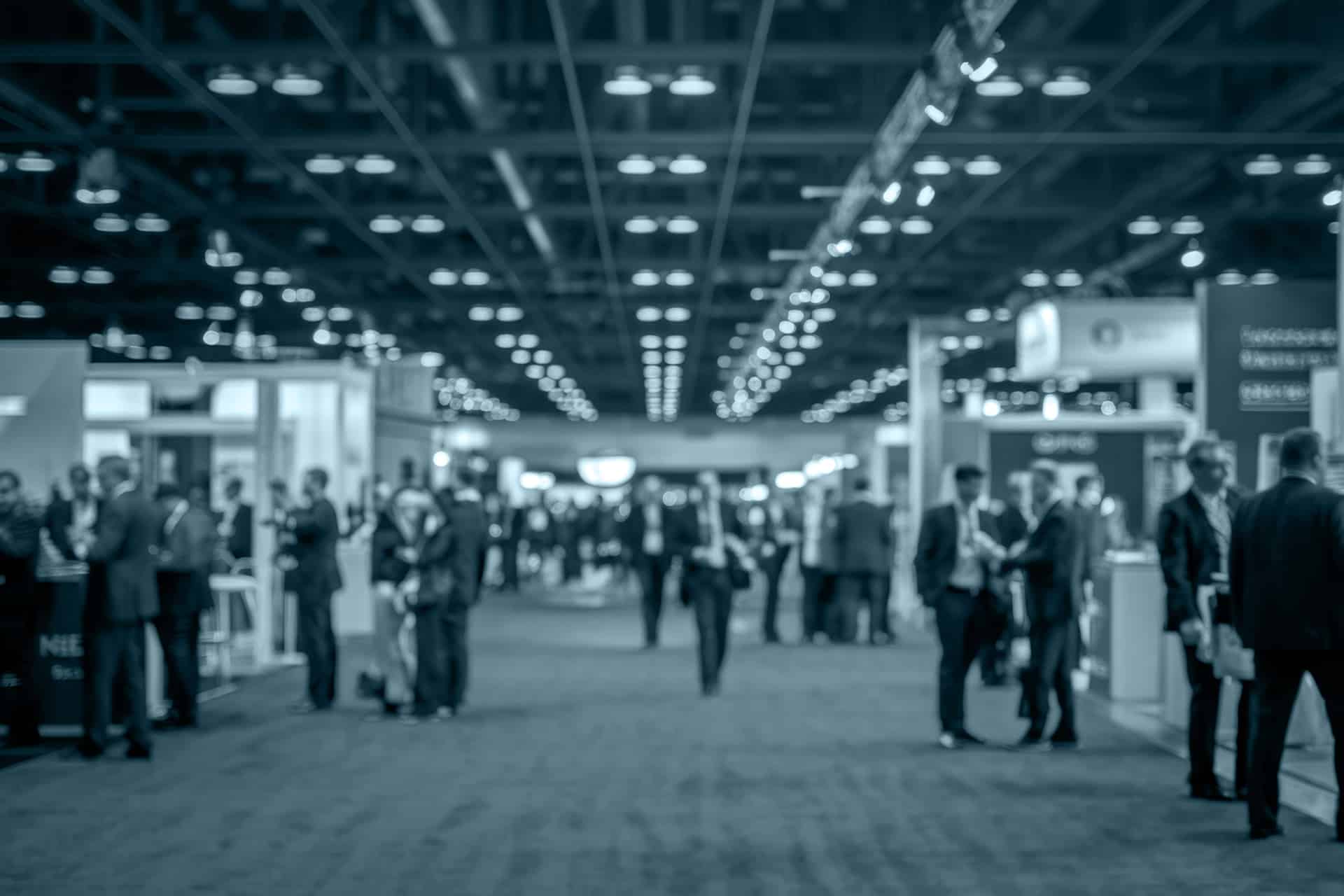 Attendees at an industrial materials testing trade show exhibit hall